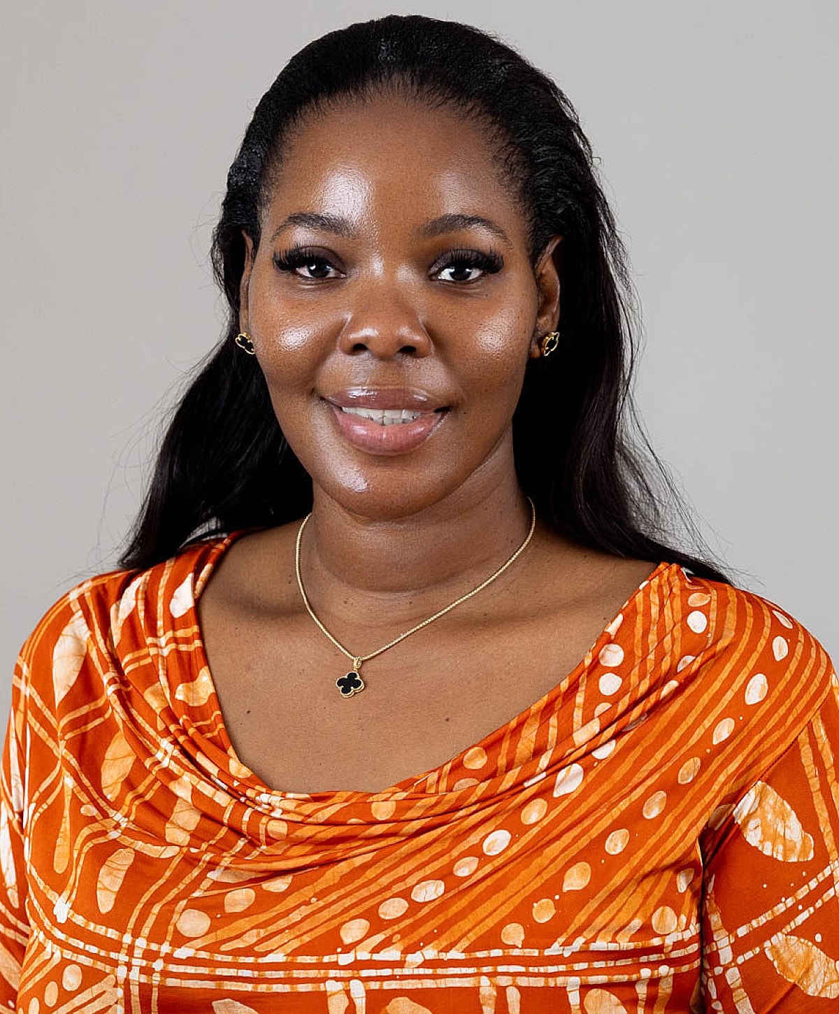 Woman in elegant blue attire, smiling confidently.
