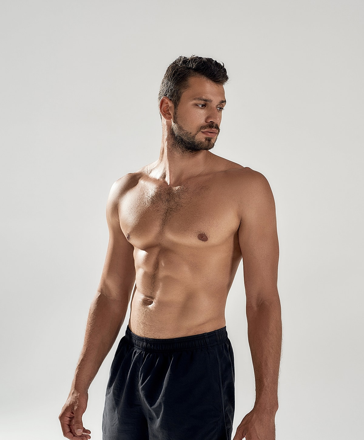 Man with muscular physique in studio setting.