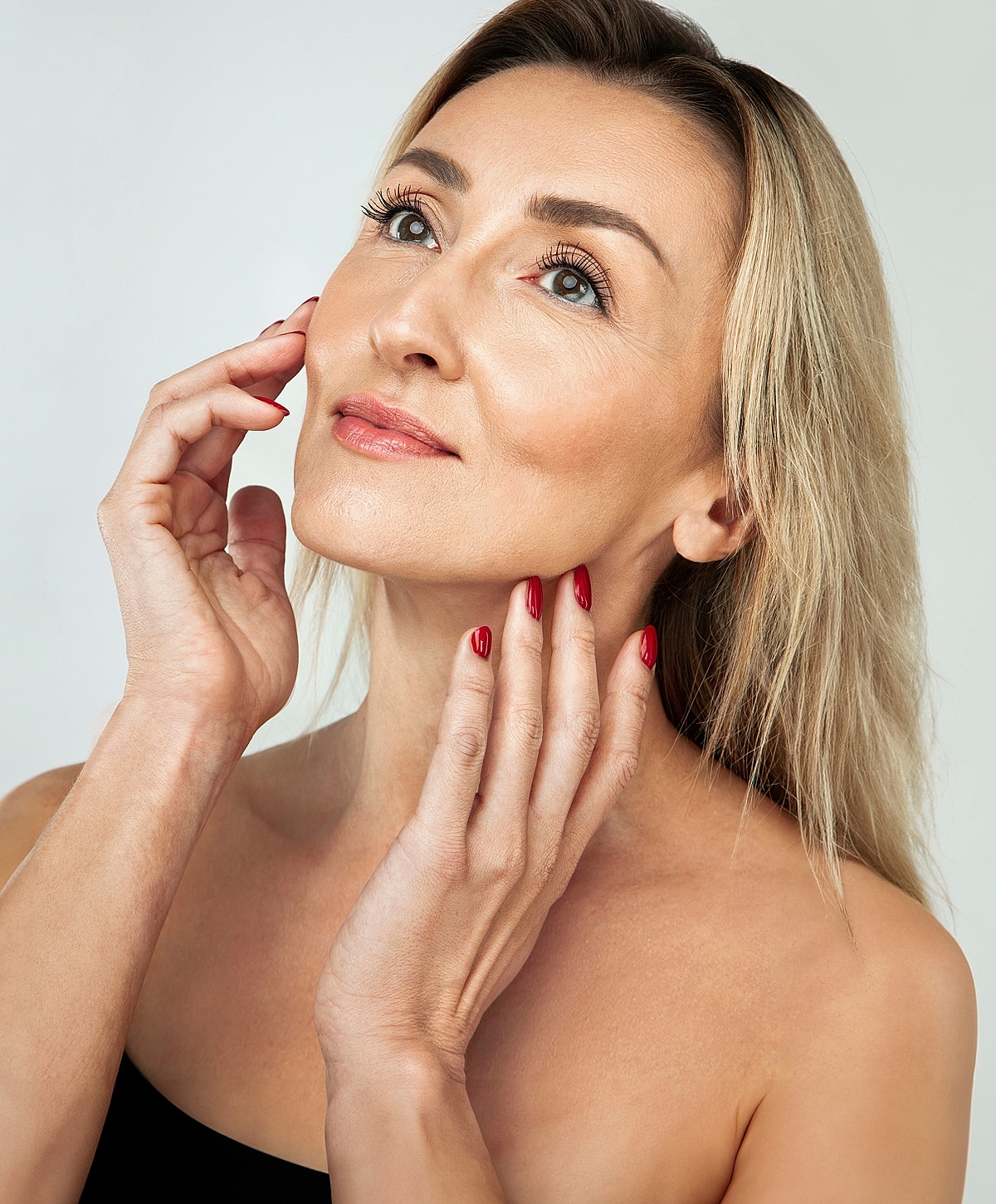Woman with beautiful skin and red nail polish.