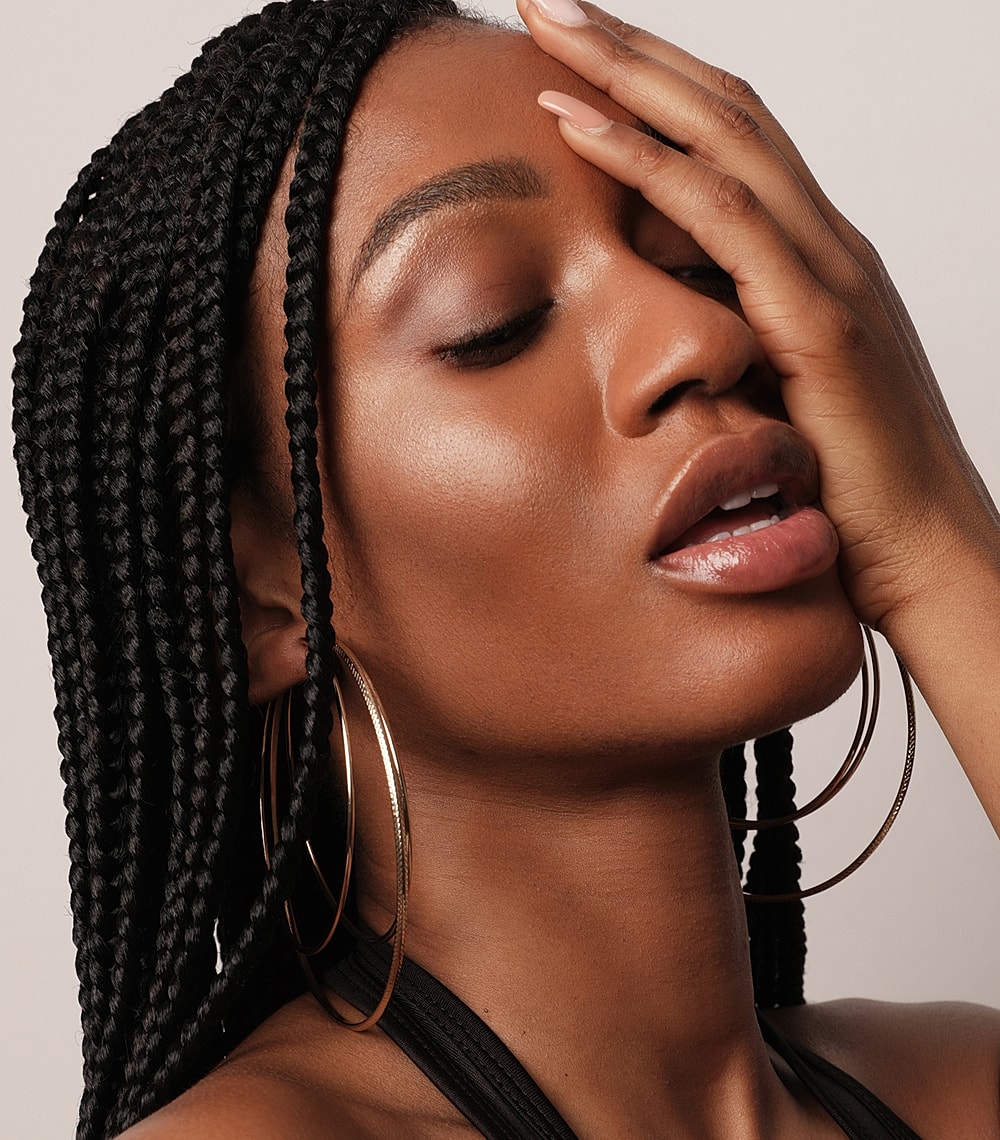 Woman with braids and large hoop earrings.