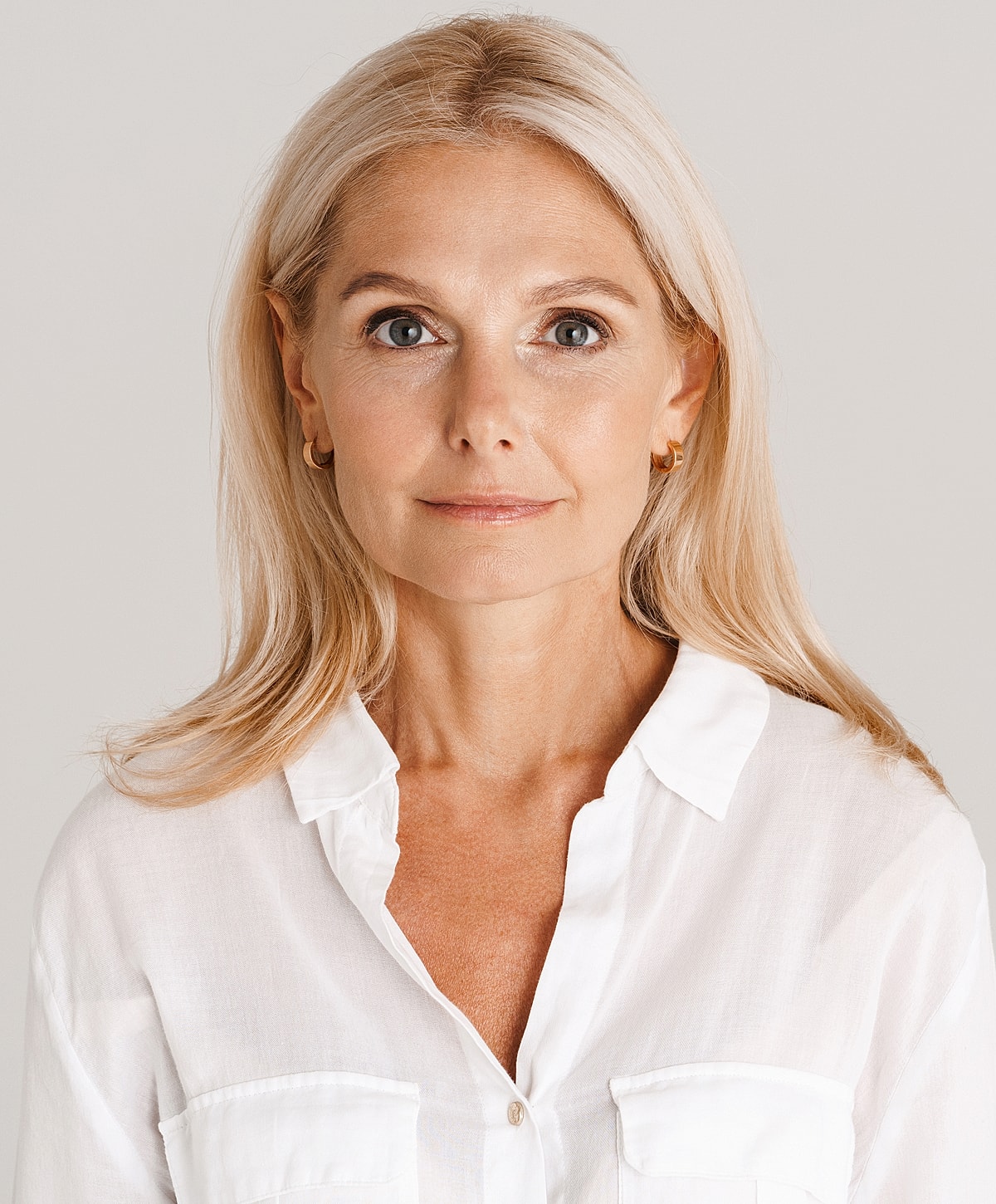 Woman with long blonde hair in white shirt.