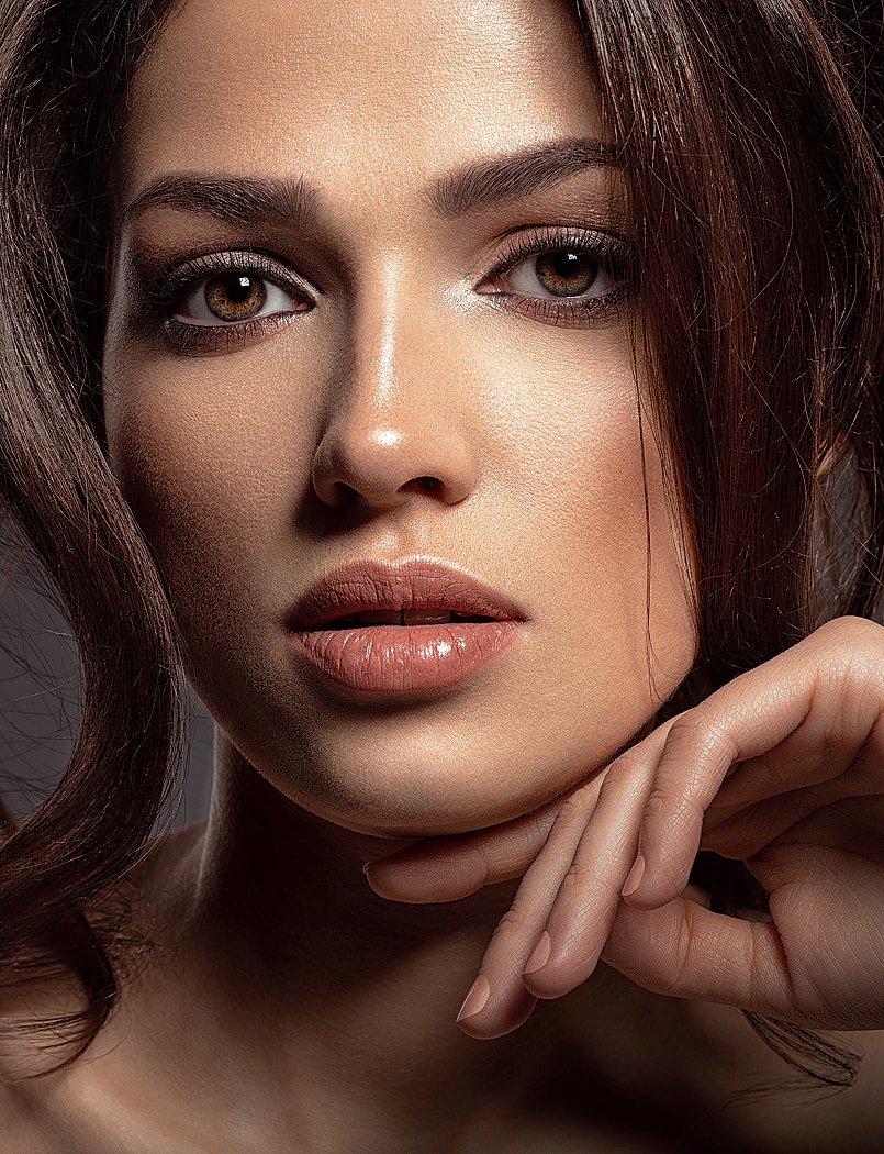 Close-up of a woman's face and hand.