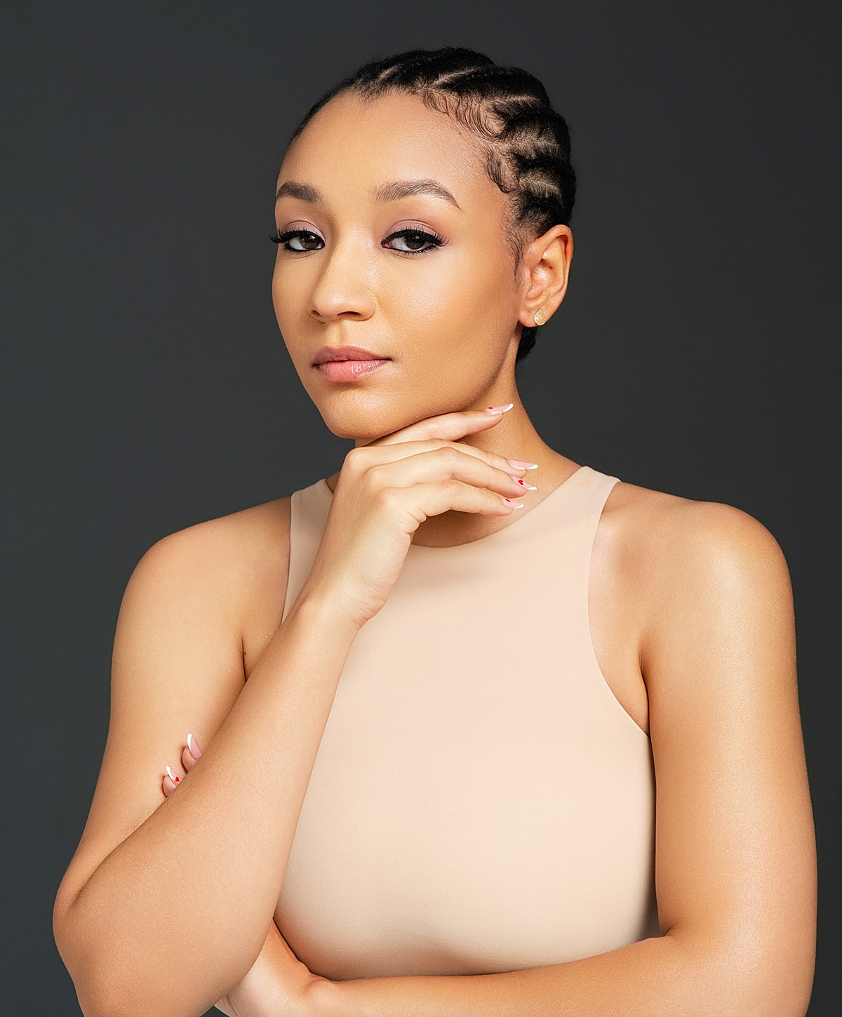 Confident model posing with hand on chin.