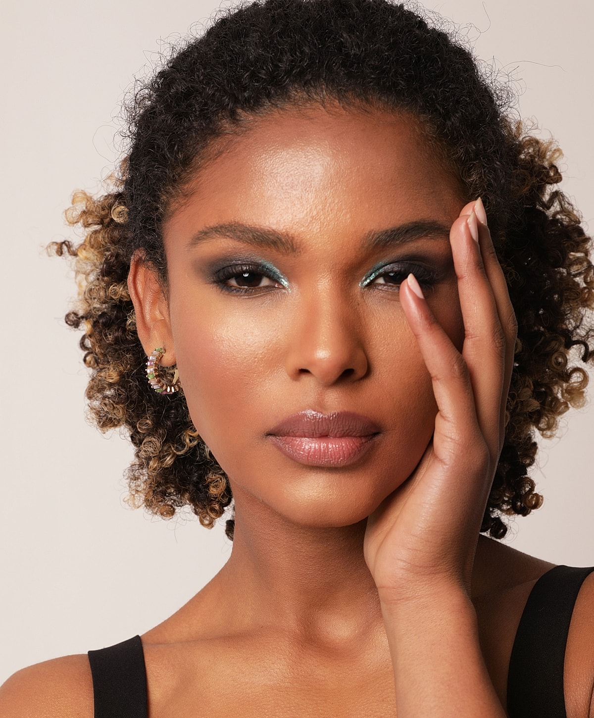 Close-up of person with curly hair and makeup.