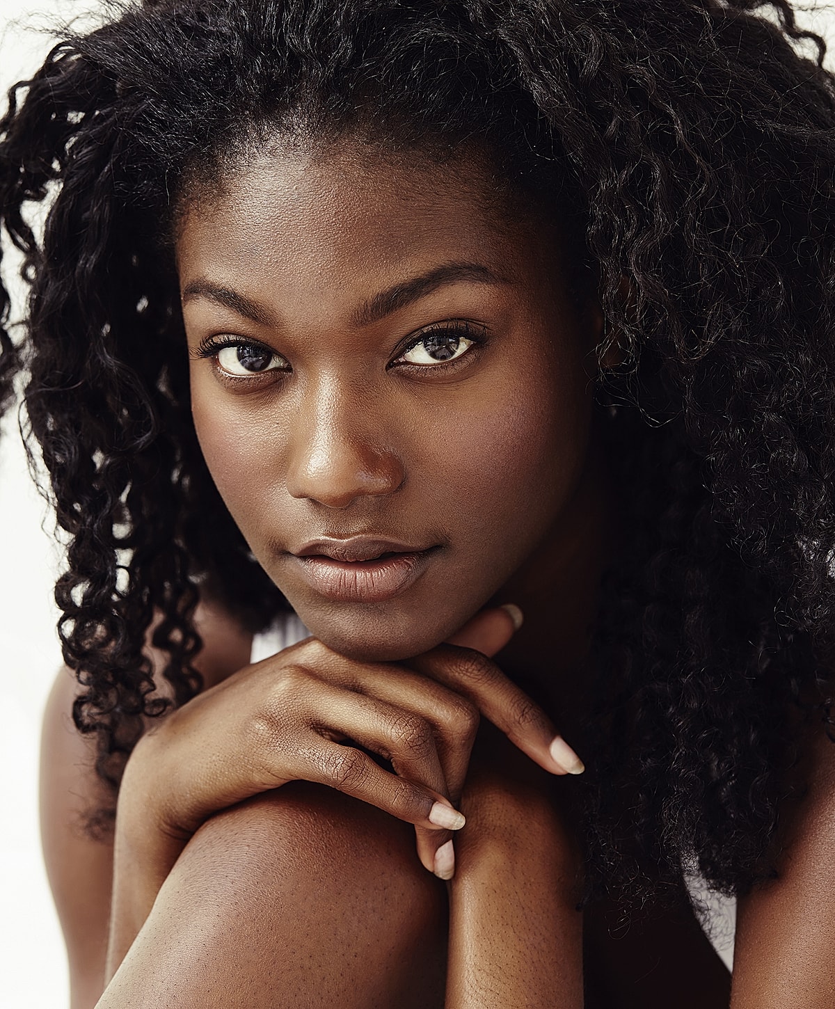 Close-up portrait of a woman with curly hair.