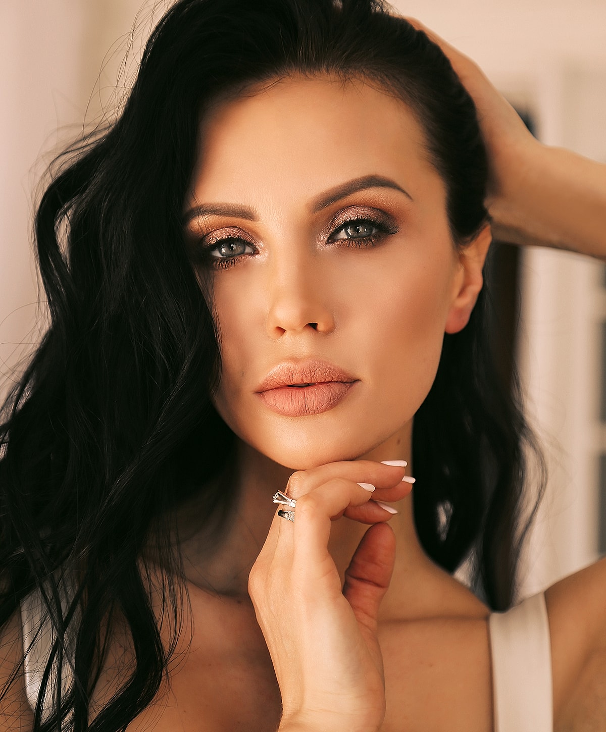 Woman with long black hair and elegant makeup.