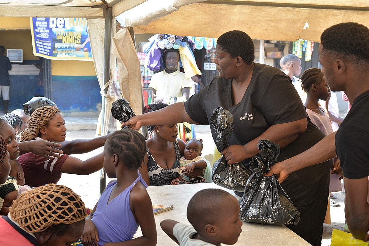 Community members receiving aid under a tent.