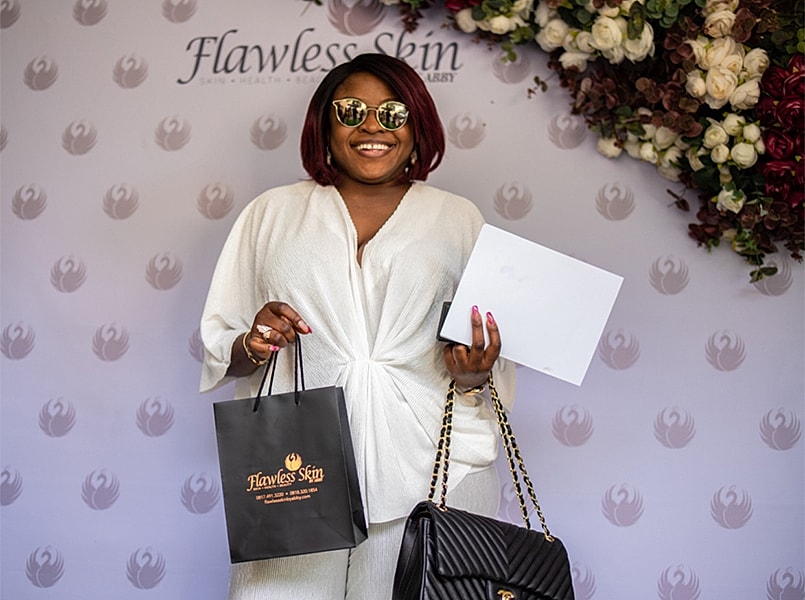 Woman holding Flawless Skin bag and package.