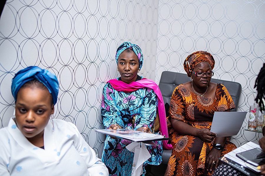 Women in colorful attire attending a meeting.