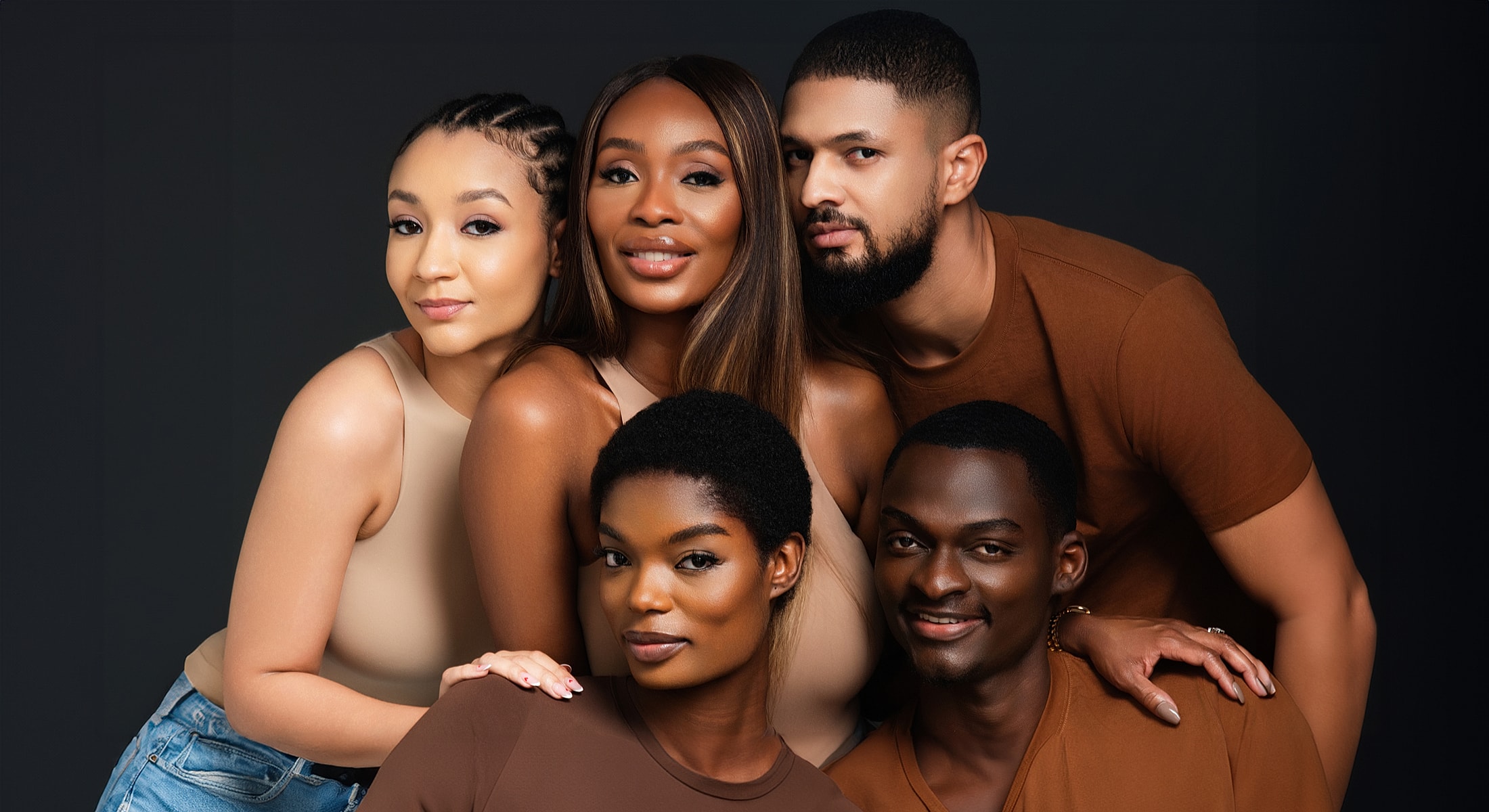 Group portrait of five stylish individuals smiling.