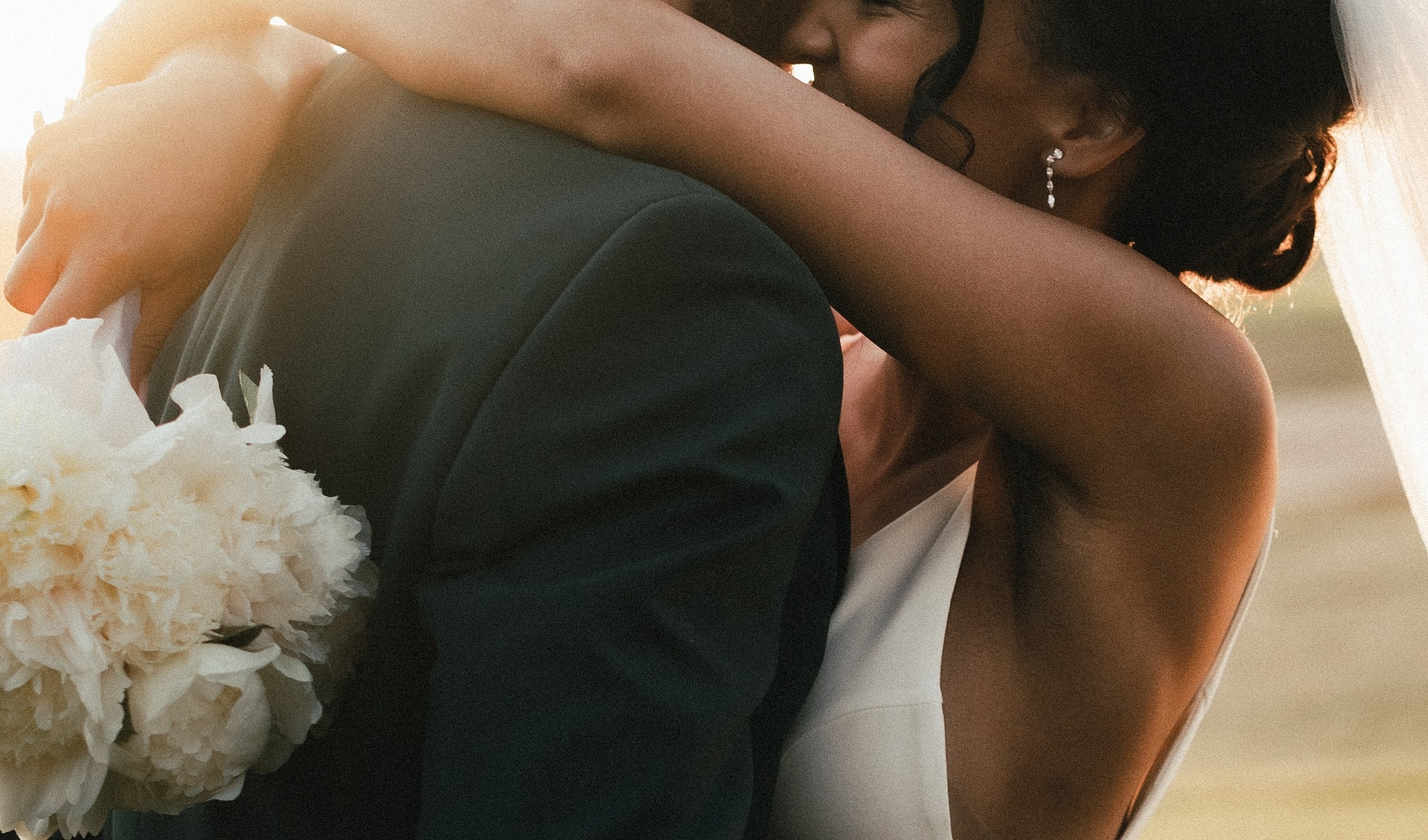 Couple embracing at sunset, wedding moment captured.