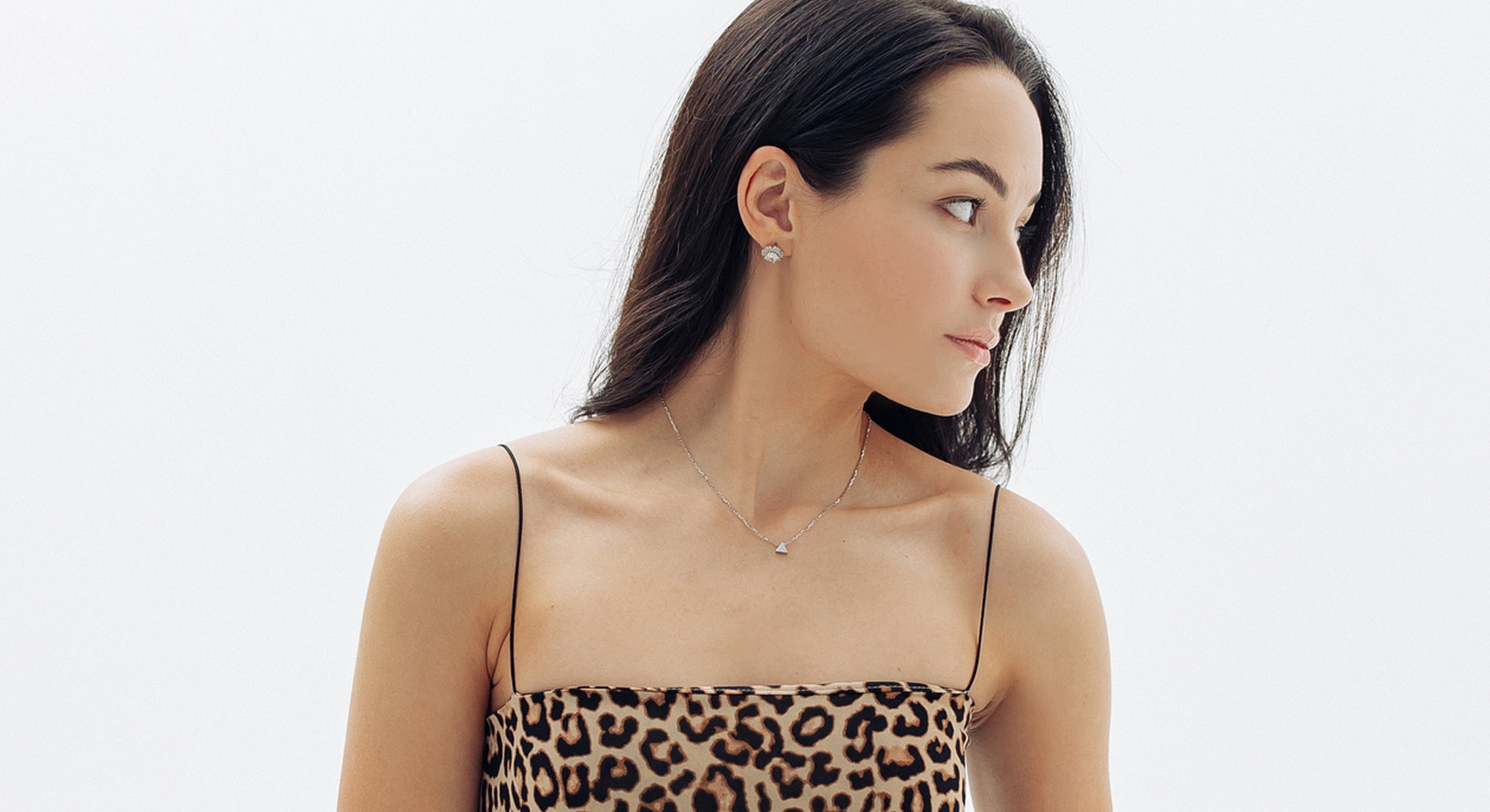 Model wearing leopard print top and jewelry.
