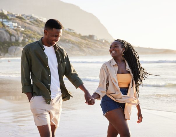 Young african couple walking along the beach