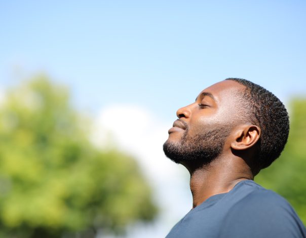 Profile of a black man breathing fresh air in nature