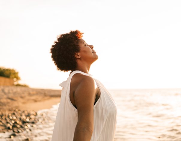 Young black woman breathing deep fresh air outdoor.